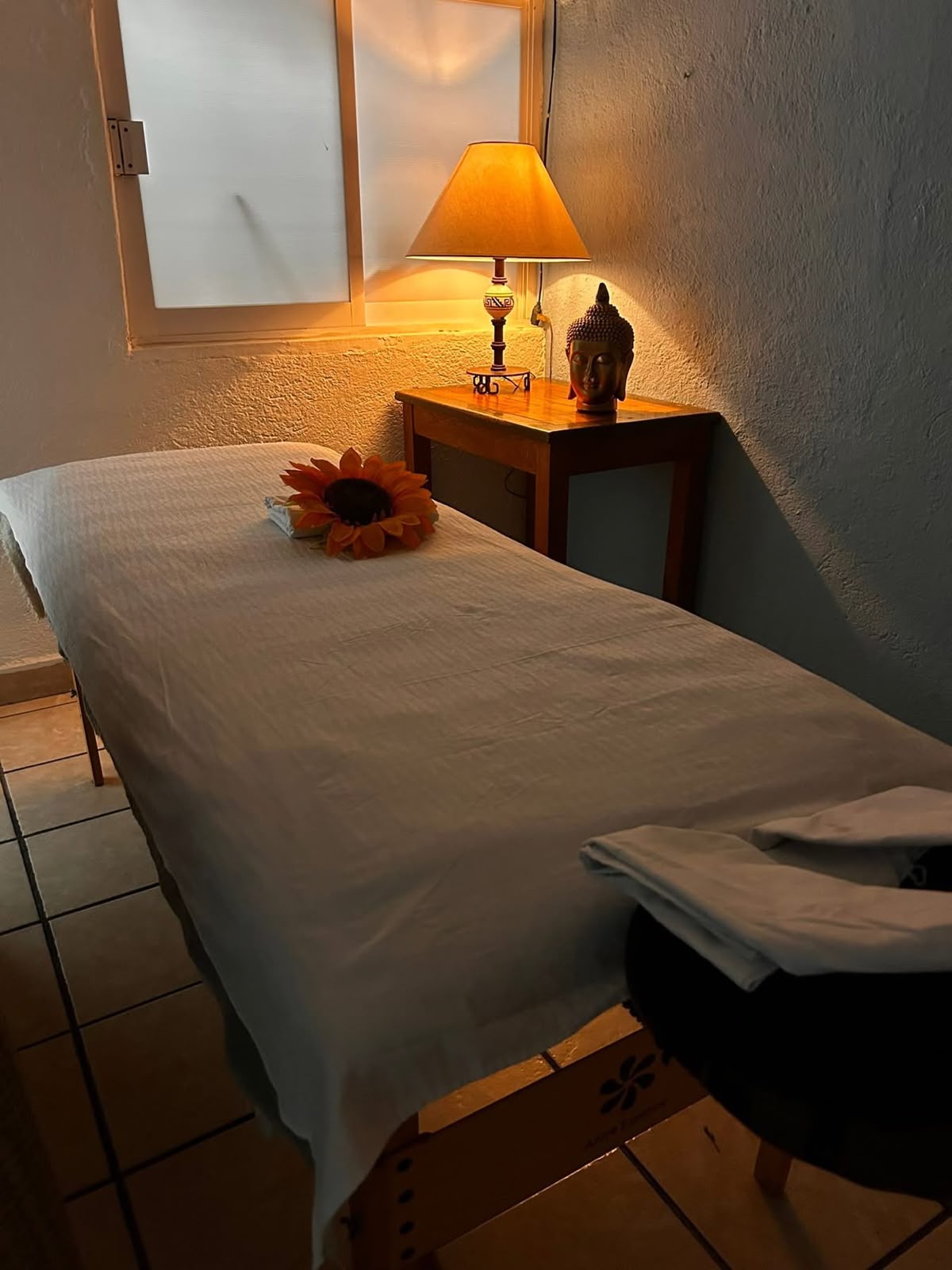 Cabina de masaje con ambiente relajante, toallas limpias y luz cálida